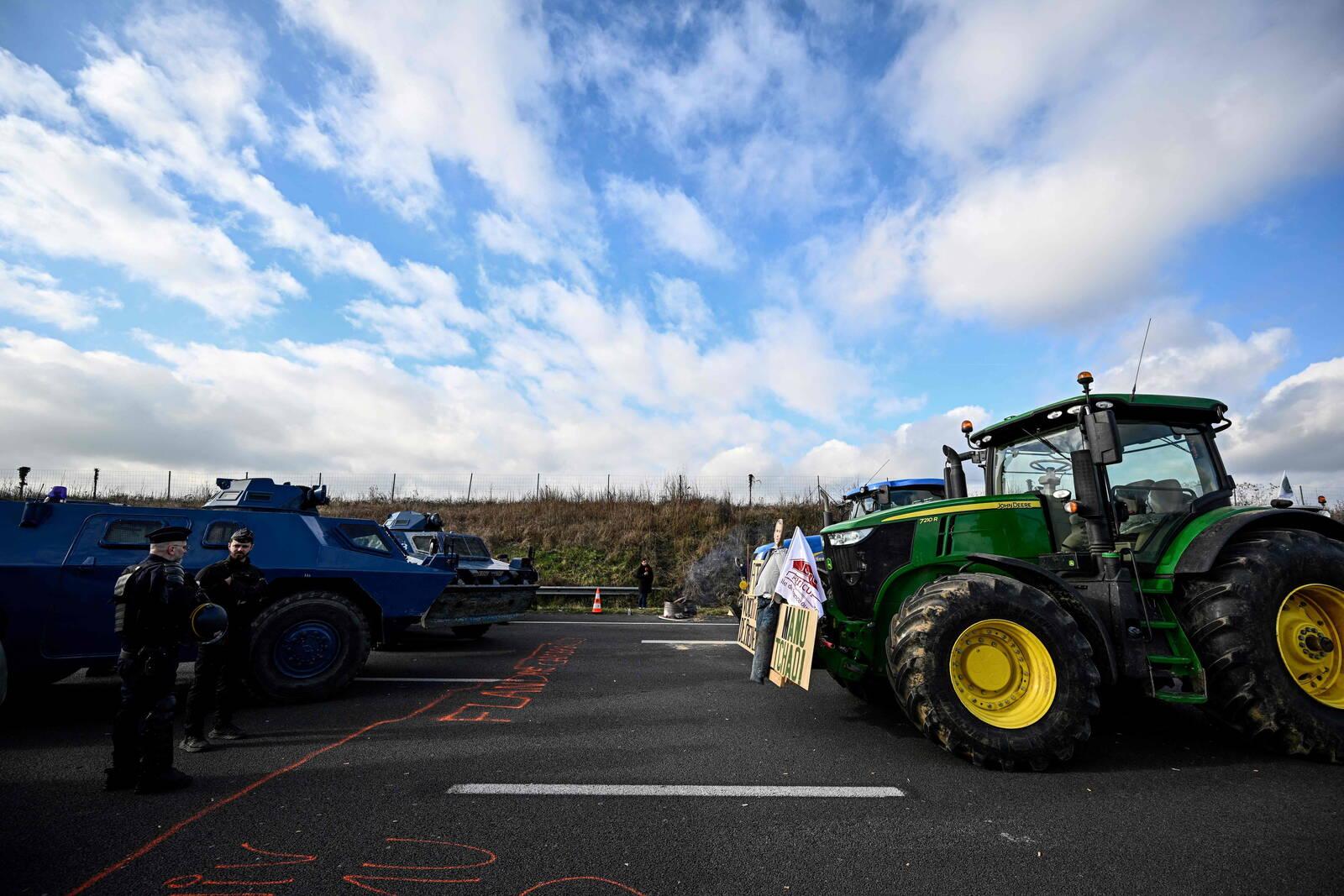 Des tracteurs affrontent des véhicules blindés de gendarmerie Berliet VXB-170 ou VBRG (Véhicule Blindé à Roues de la Gendarmerie) sur l'autoroute A1 près de Chennevières-les-Louvres, à proximité de l'aéroport Roissy-Charles-de-Gaulle, au nord-ouest de Paris, le 31 janvier 2024, alors que les agriculteurs français maintiennent des barrages routiers sur les principales autoroutes menant à Paris pour un troisième jour, dans le cadre de manifestations à l'échelle nationale convoquées par plusieurs syndicats d'agriculteurs contre le dumping étranger, les impôts et la réglementation. Des convois de tracteurs se sont rapprochés de Paris, Lyon et d'autres endroits stratégiques en France le 31 janvier, alors que des milliers d'agriculteurs protestataires semblaient ignorer les avertissements d'intervention de la police s'ils franchissaient les lignes rouges fixées par les ministres. Les syndicats d'agriculteurs, peu impressionnés par les concessions proposées par le gouvernement présidentiel, ont encouragé leurs membres à poursuivre leur lutte pour des revenus plus élevés, moins de bureaucratie et une protection contre la concurrence étrangère. (Photo de JULIEN DE ROSA / AFP)